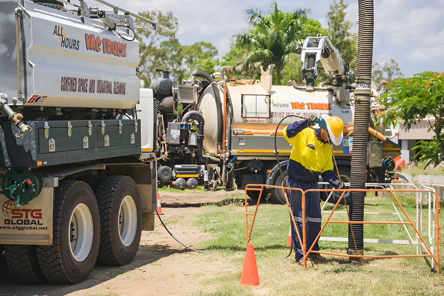 A Man Is Standing In Front Of A Large Truck — All Hours Vac Truck In Rockhampton, QLD