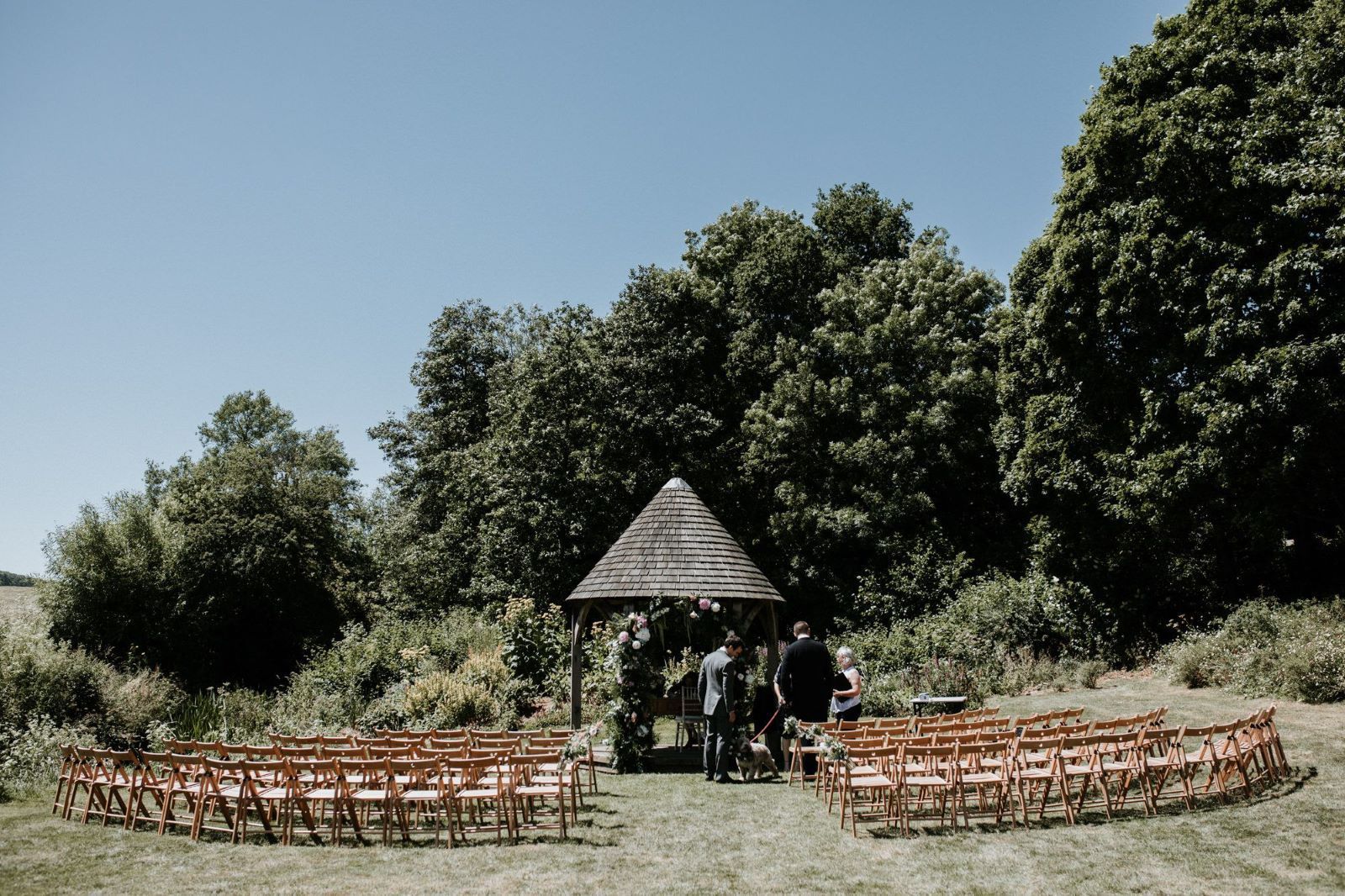 A row of chairs are lined up in a circle in front of a gazebo.