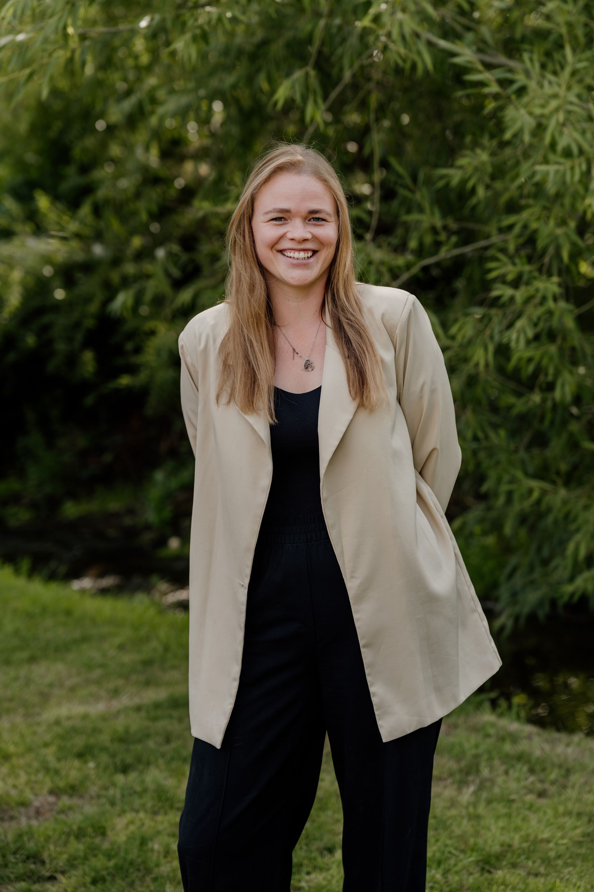 A woman in a blue jacket is standing on a bridge in front of a building.