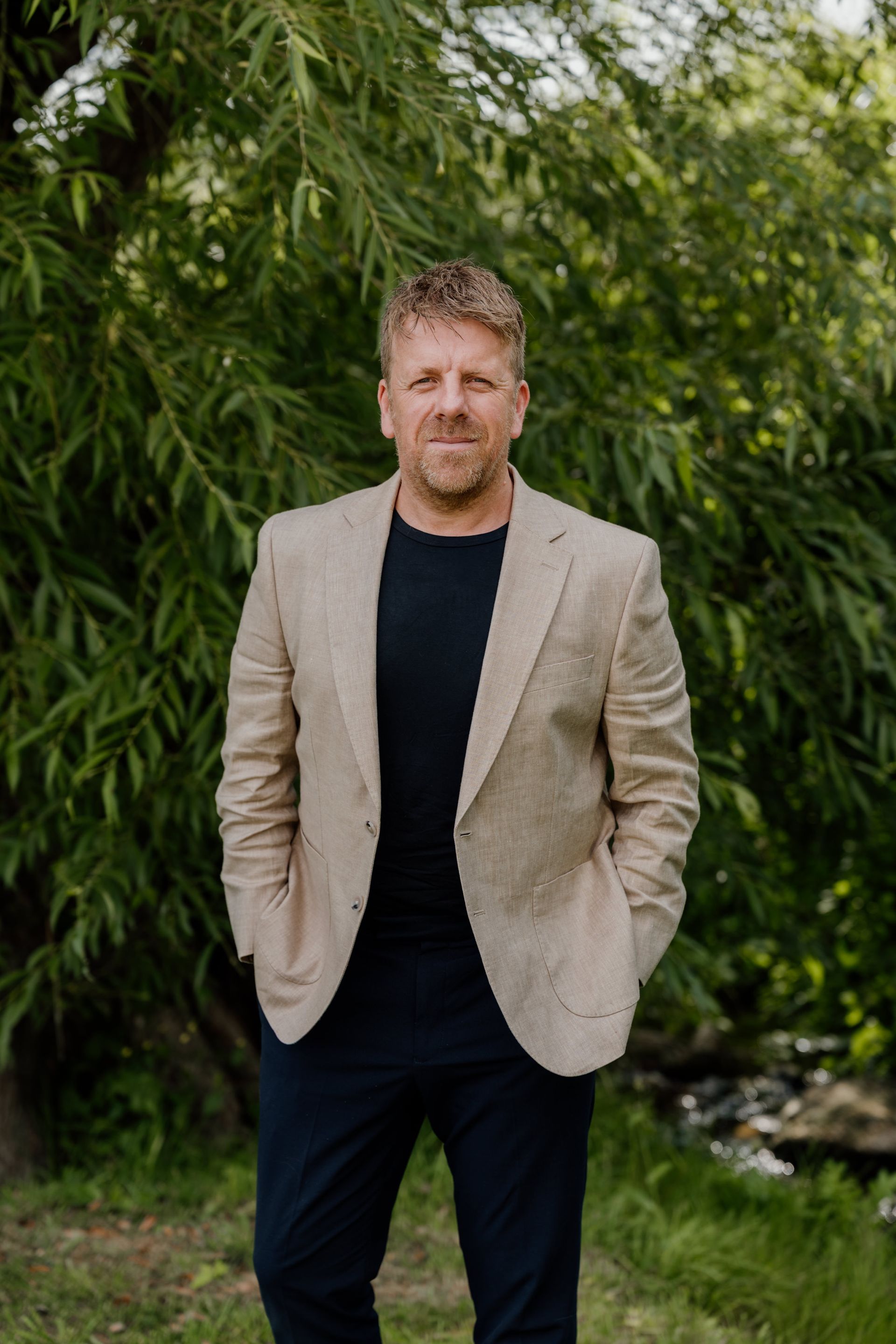 A man in a suit and tie is standing in front of a building.