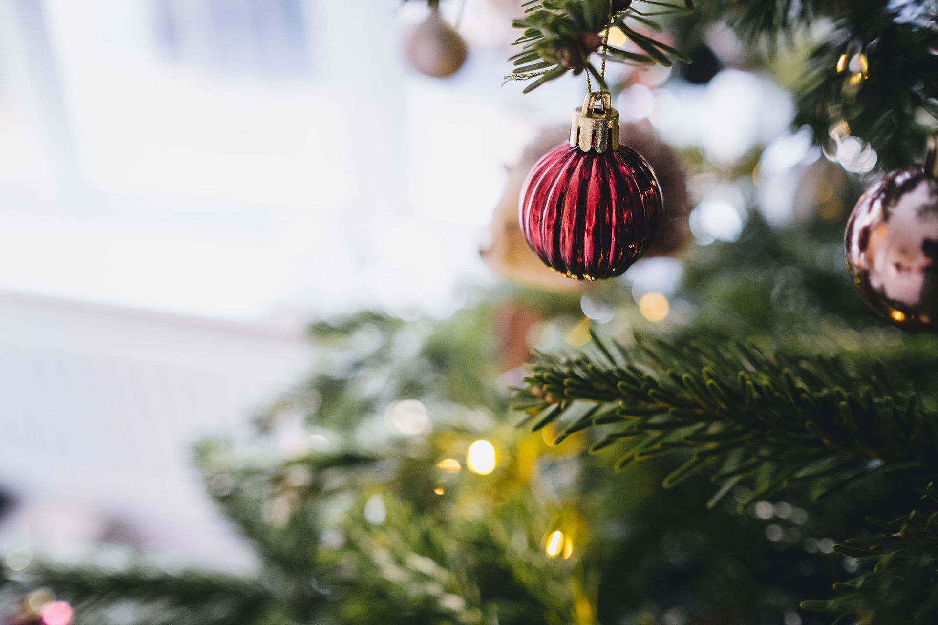 A close up of a christmas tree with decorations hanging from it.