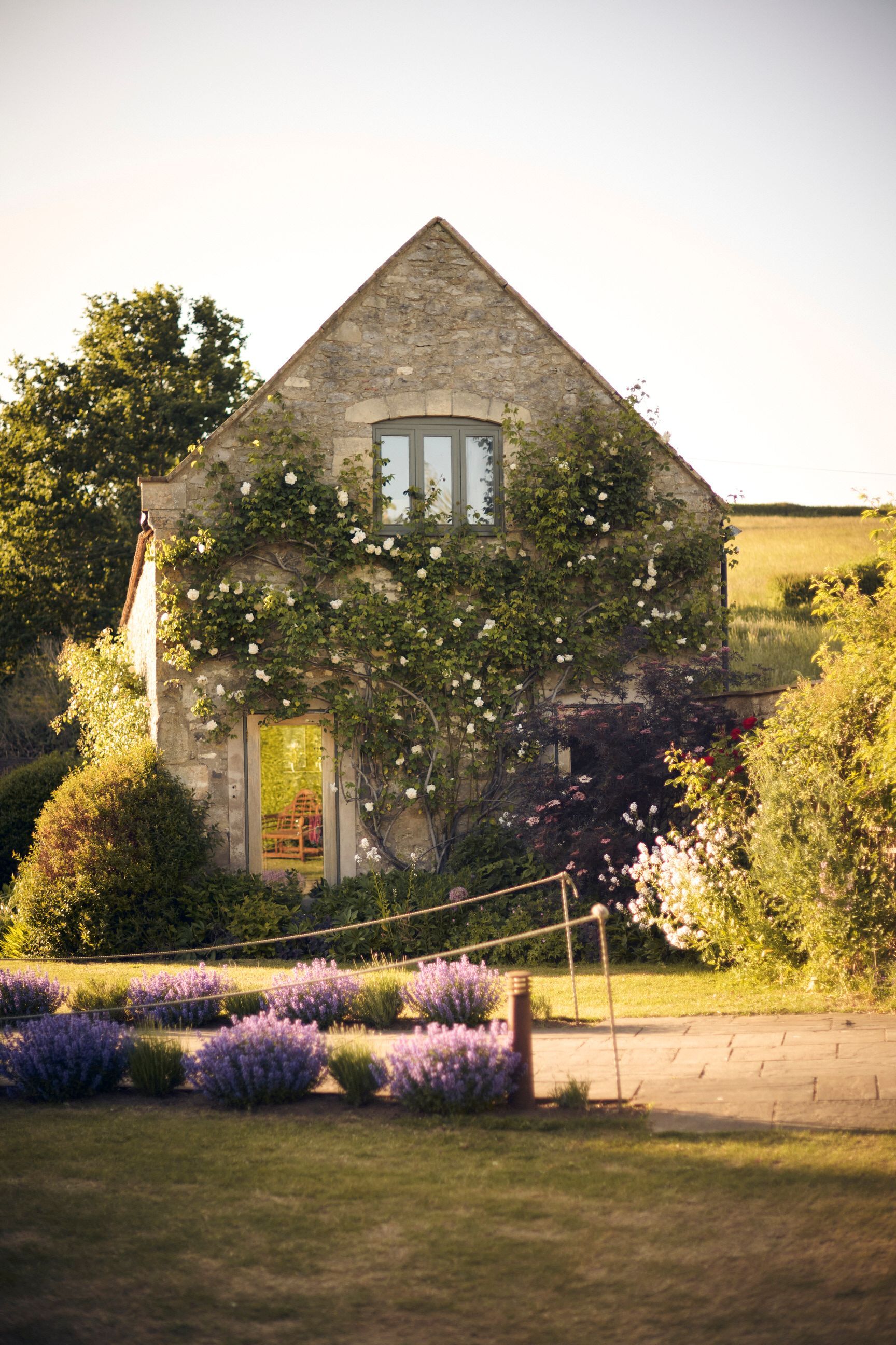 There is a house with a lot of flowers in front of it.