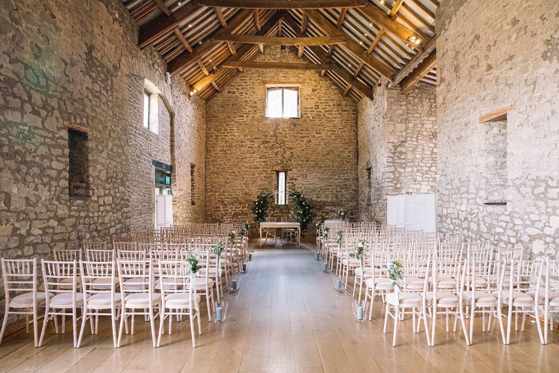 A large stone building with rows of chairs and a wooden floor.