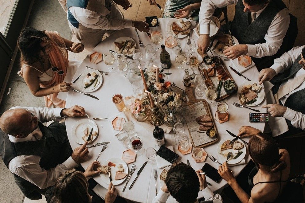 A group of people are sitting around a table eating food.