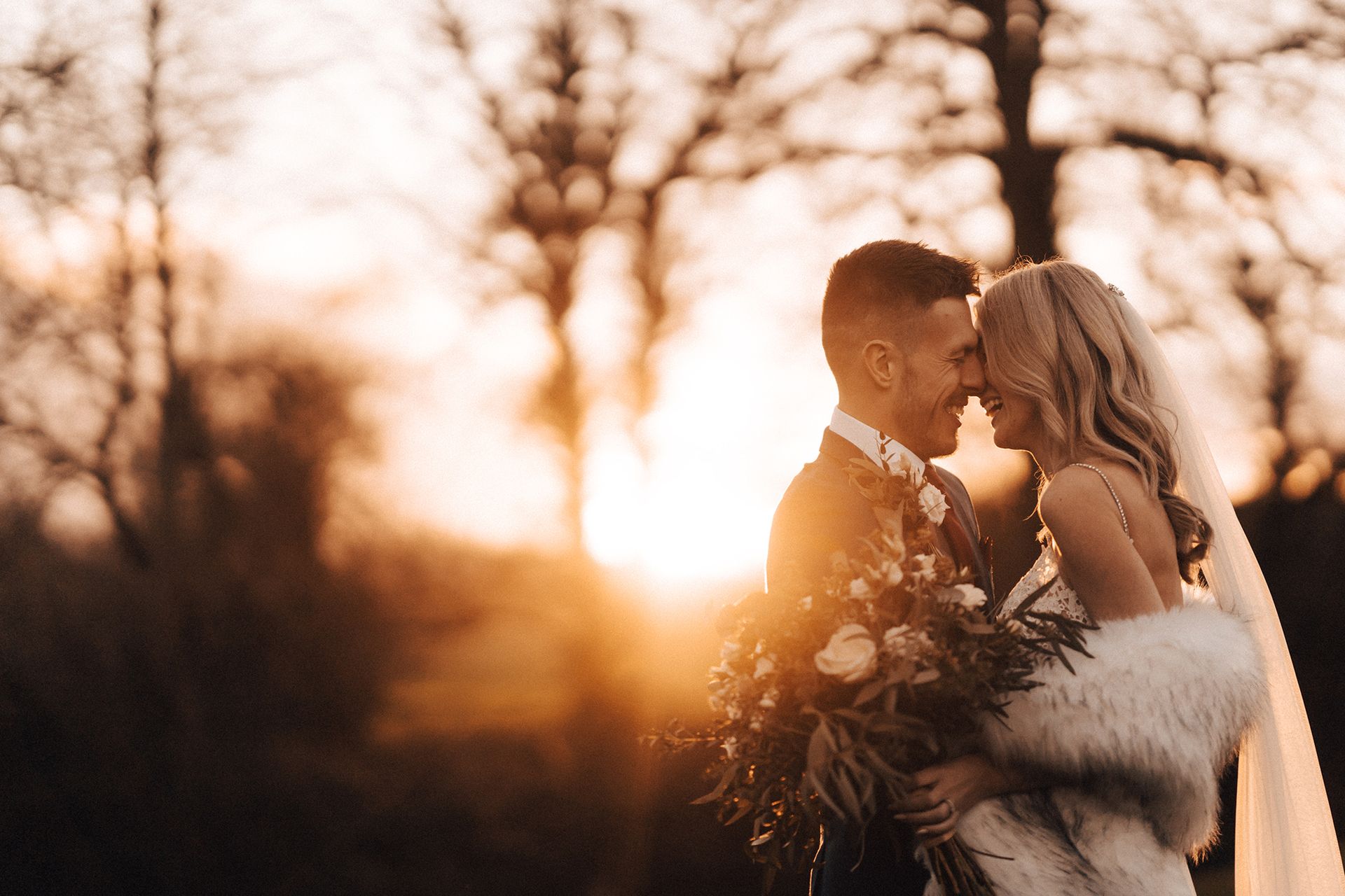 a bride and groom are standing in front of a crowd during their wedding ceremony .
