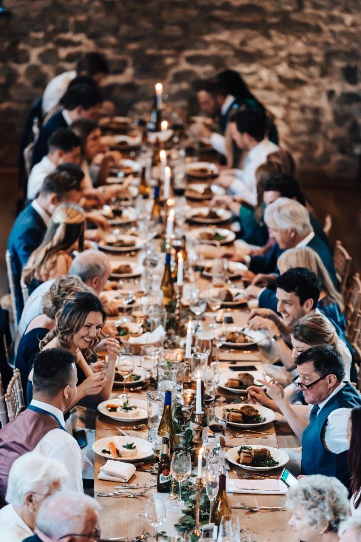 A group of people are sitting at a long table eating food.