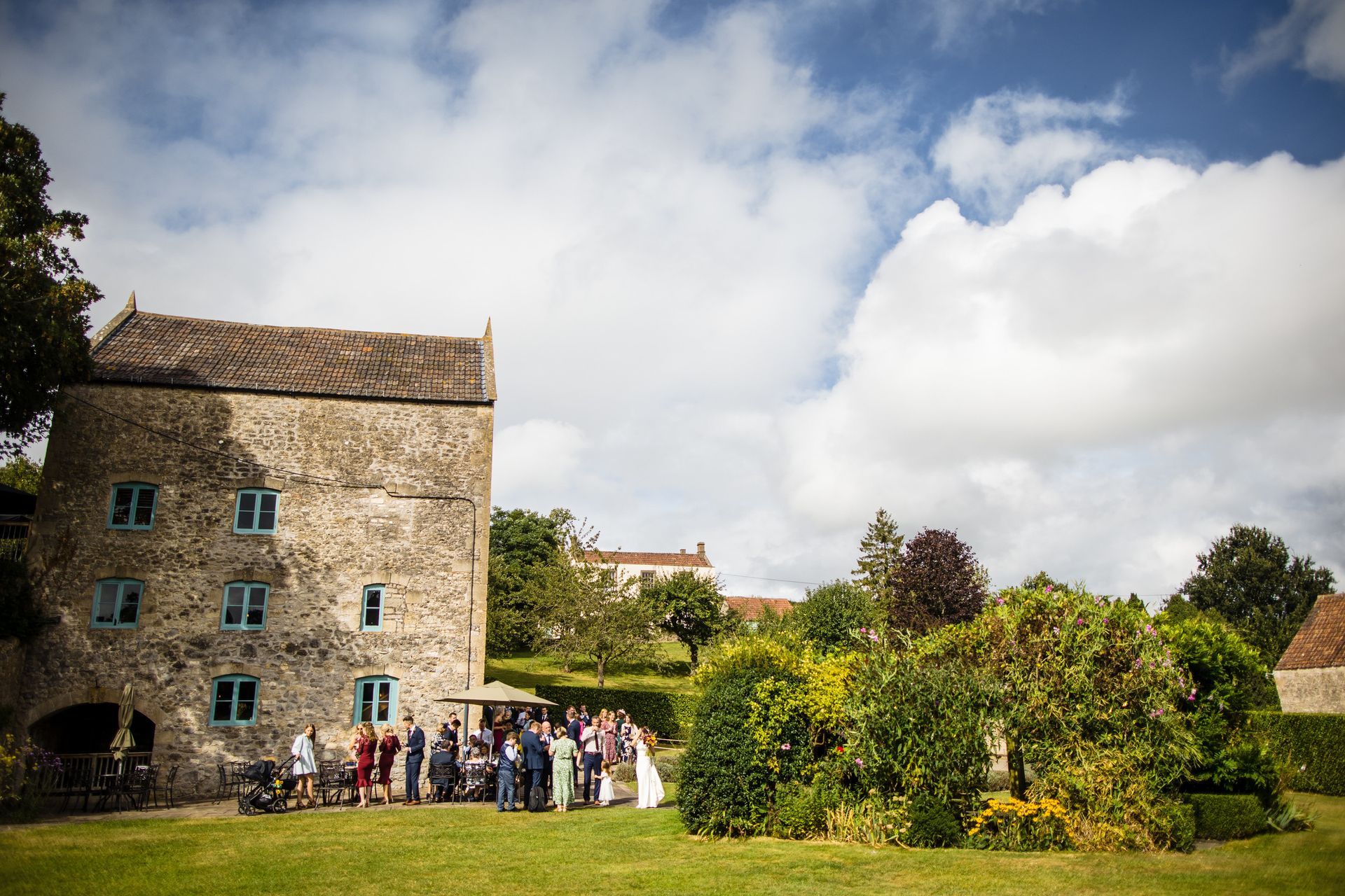 A group of people are standing in front of a large stone building.