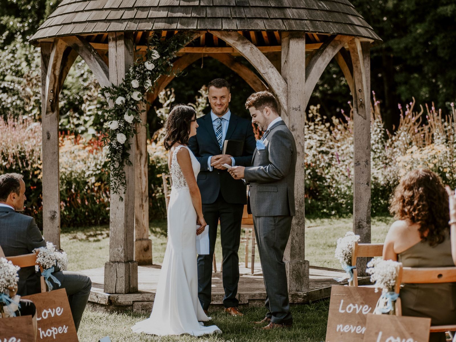 a bride and groom are standing in front of a crowd during their wedding ceremony .