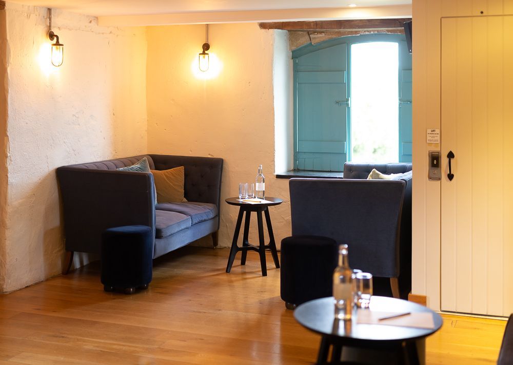 A living room with a couch , two tables , and a window.