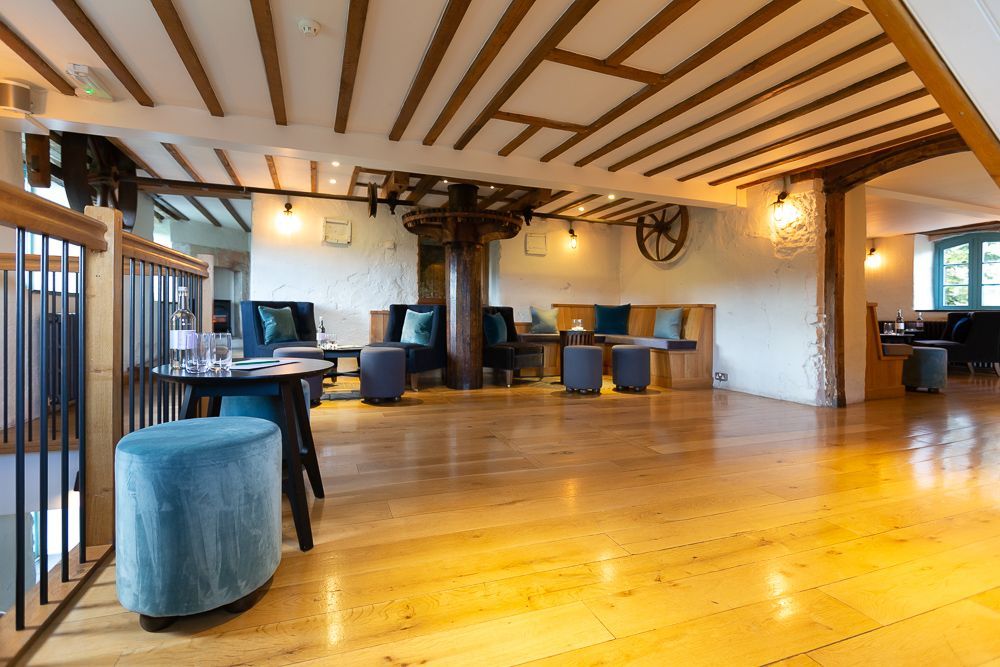 A large room with wooden floors and tables and chairs.