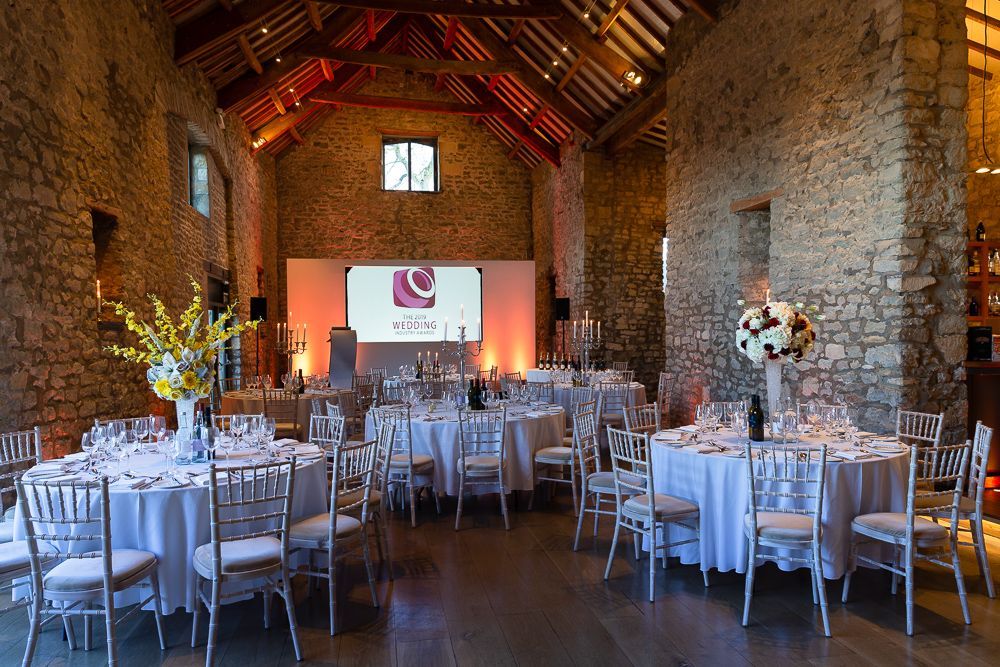 A large room with tables and chairs set up for a wedding reception.
