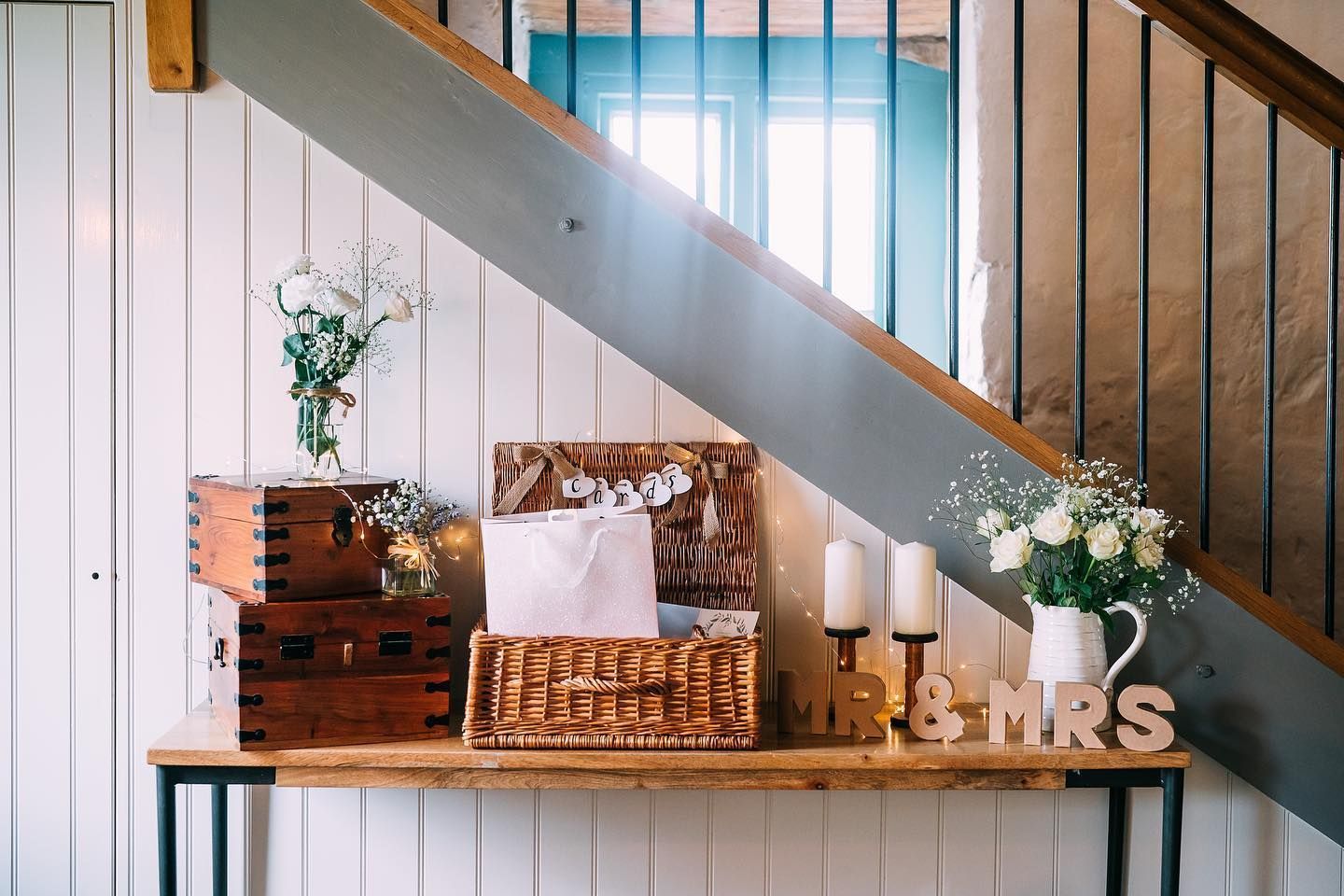 There is a table under the stairs with a sign that says mr. and mrs.