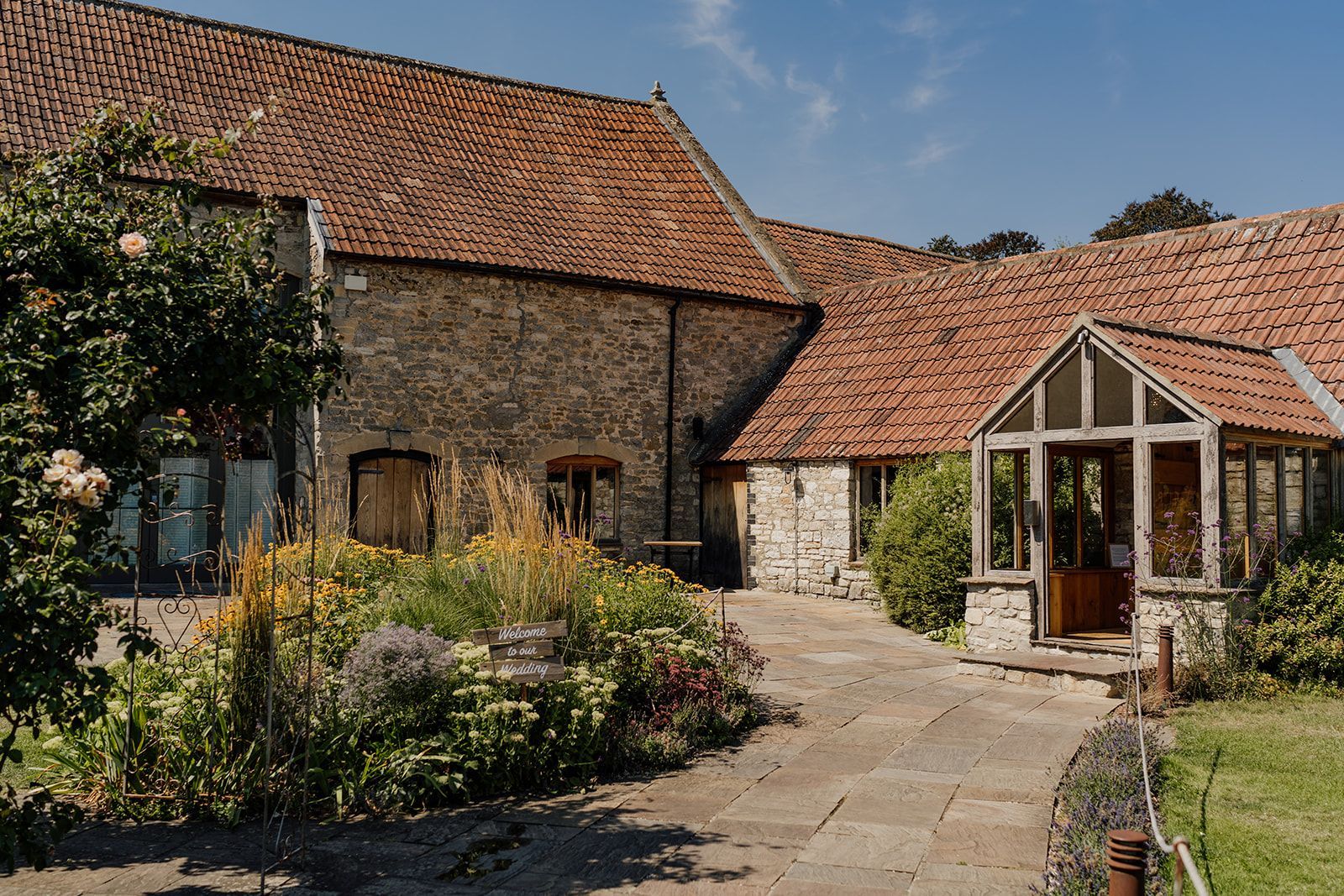 A large stone building with a brick roof and a walkway leading to it.
