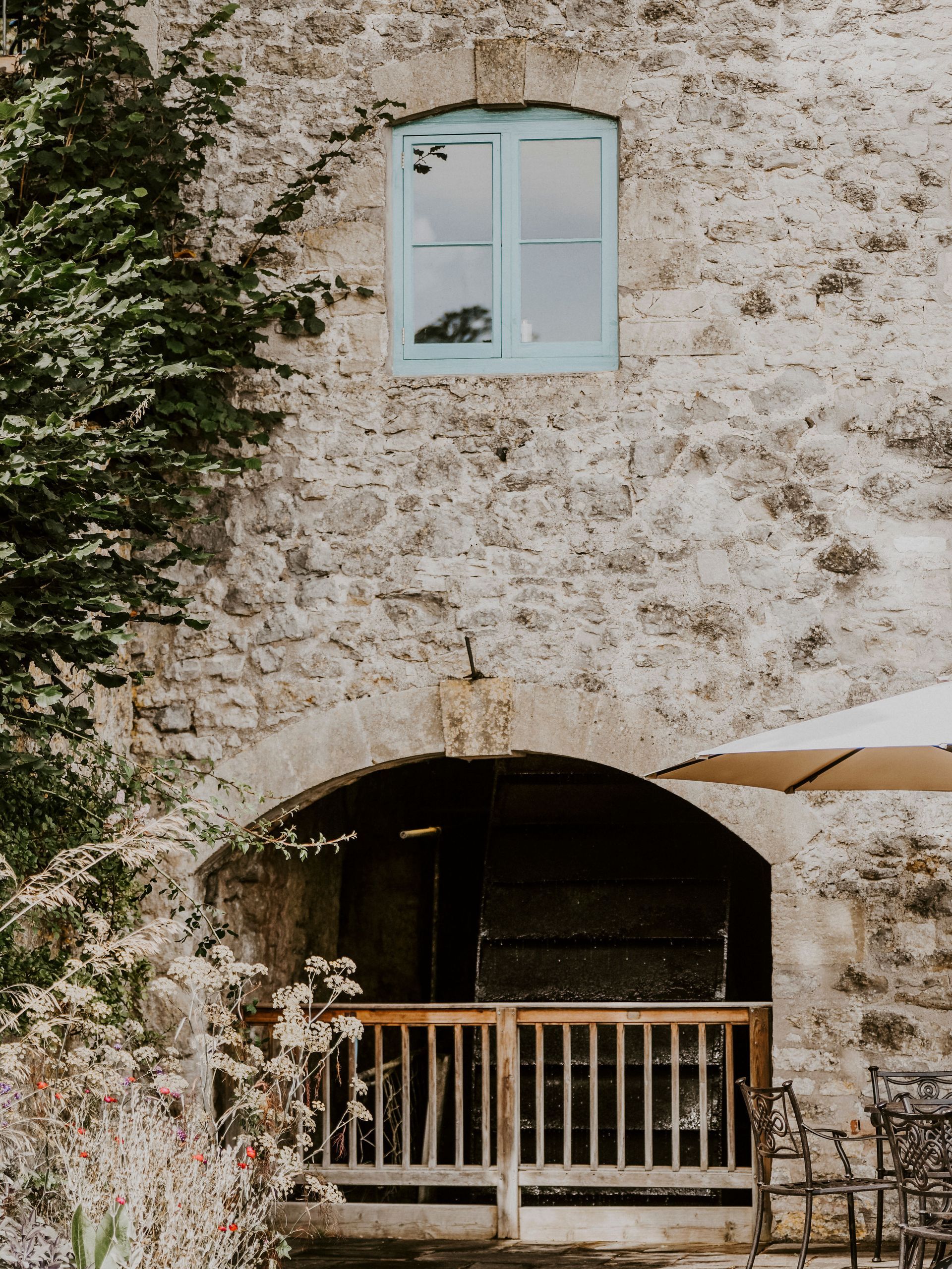A stone building with a balcony and a blue window