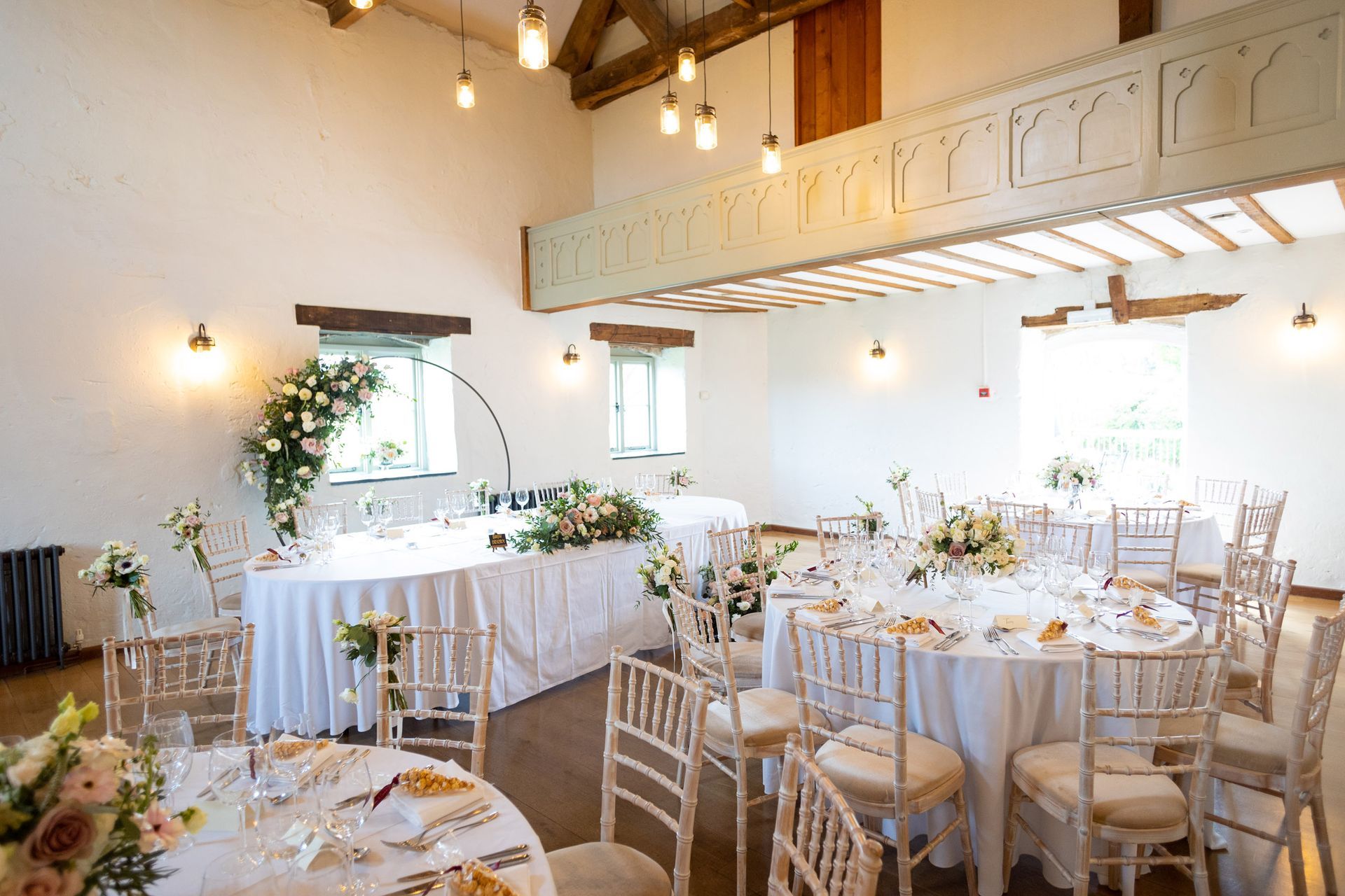 A large room with tables and chairs set up for a wedding reception.