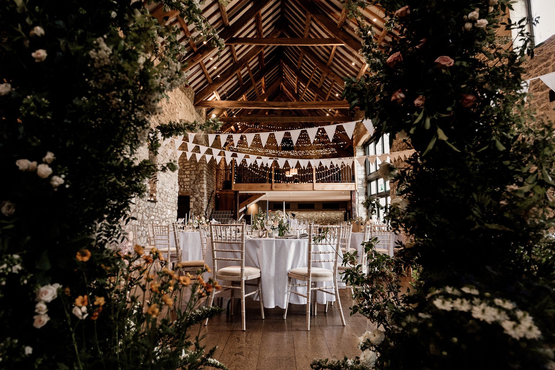 A large room with tables and chairs set up for a wedding reception.