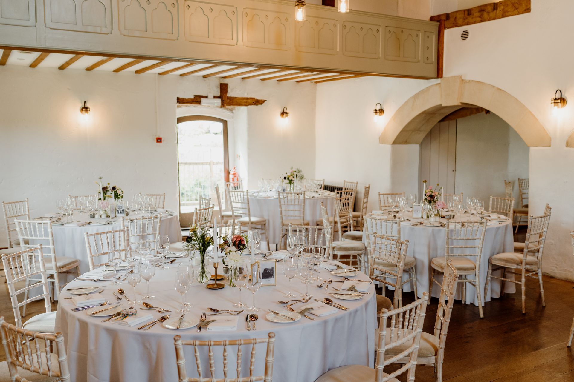 A large room with tables and chairs set up for a wedding reception.