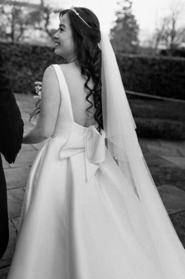 A black and white photo of a bride in a wedding dress and veil.