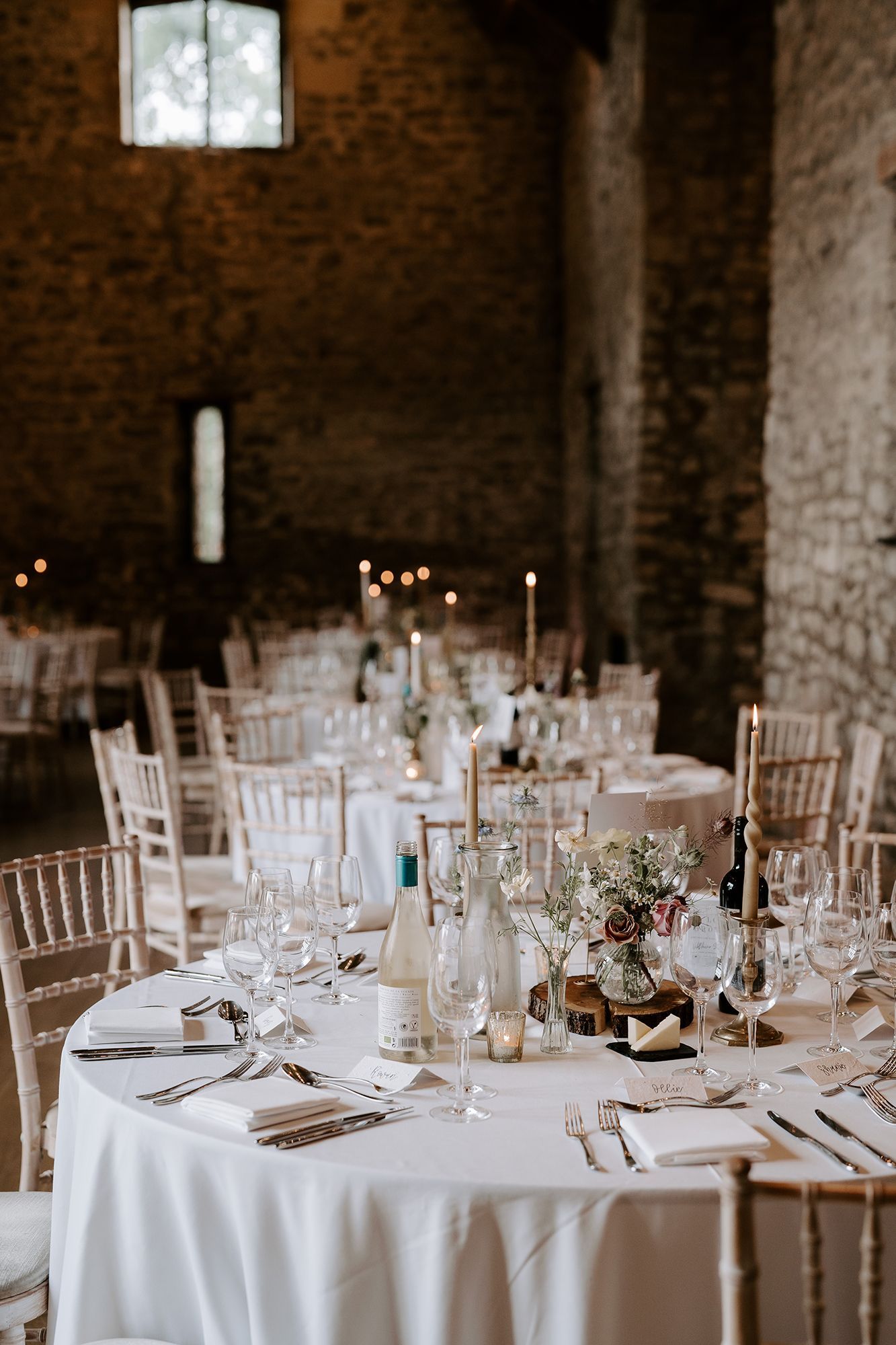 A room filled with tables and chairs set up for a wedding reception.
