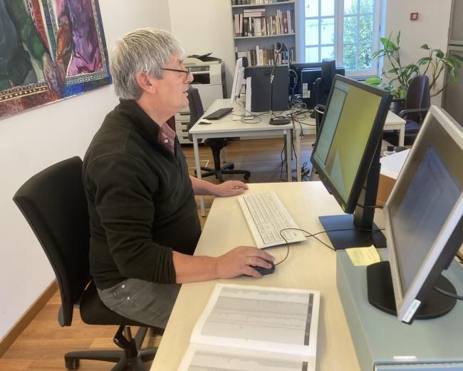 Man at computer desk researching on computers