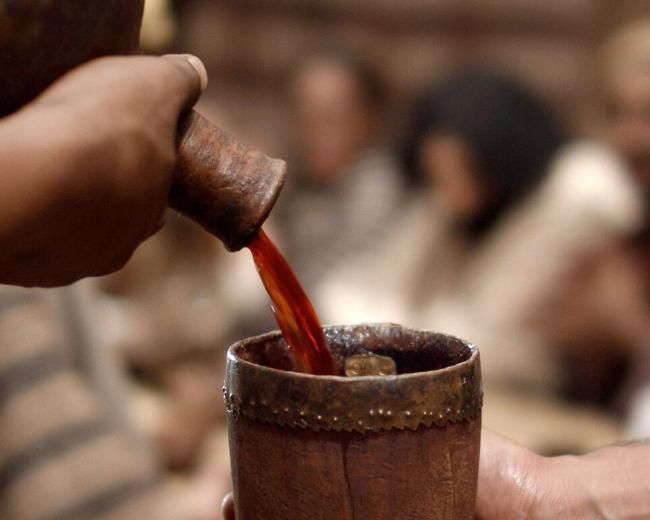 A hand pours wine into a cup