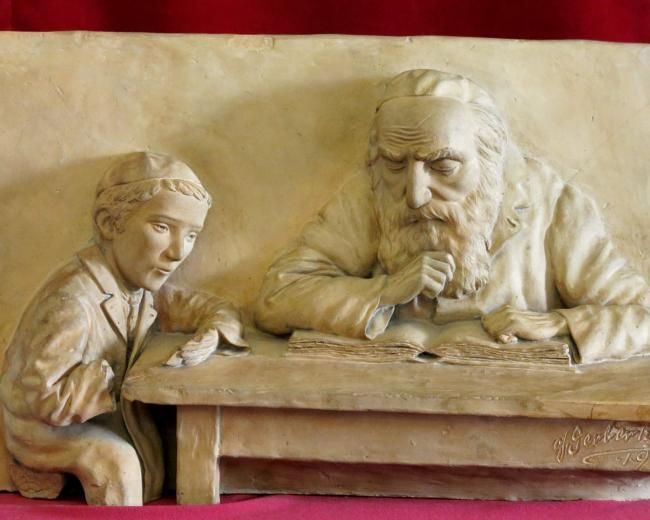Sculpture with older Jewish man teaching younger Jewish man Scriptures