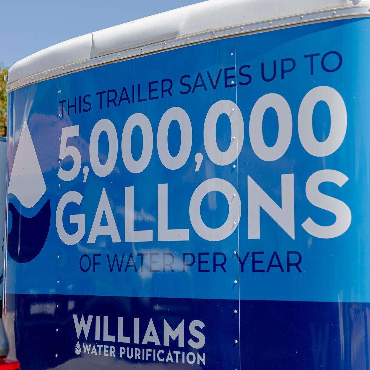 A trailer that says williams on it is parked in a parking lot