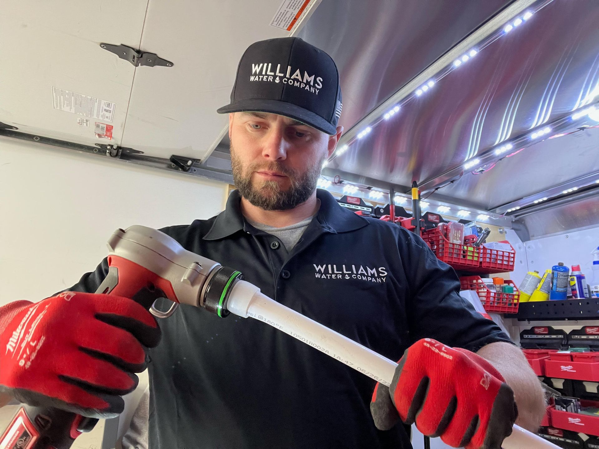 Two children are washing grapes in a kitchen sink.