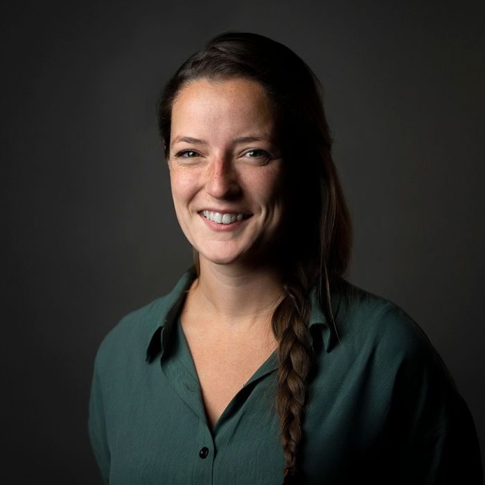 A woman in a green shirt is smiling for the camera.