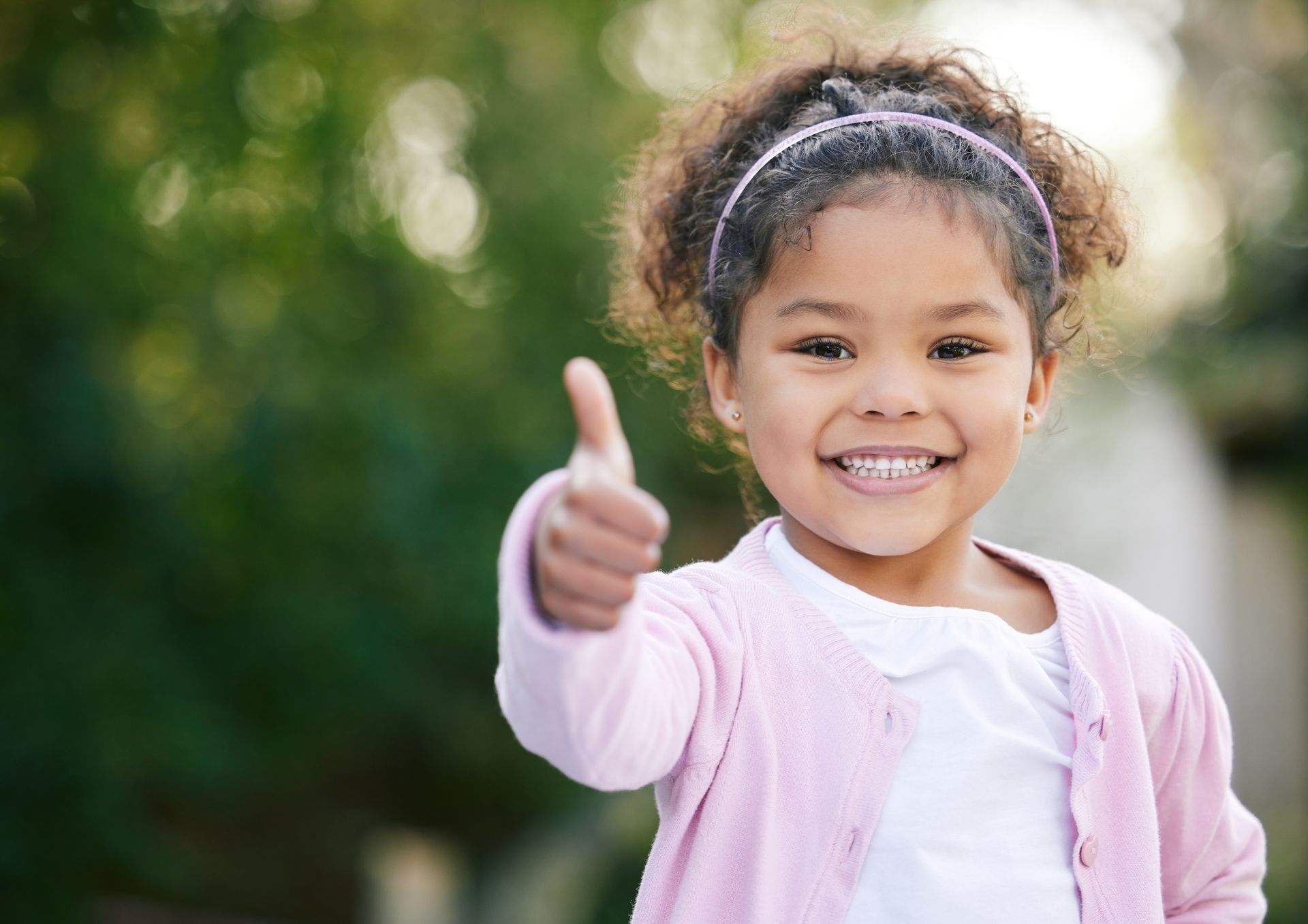 A girl is giving a thumbs up