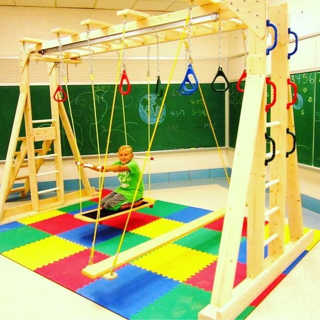 A boy in a green shirt is sitting on a swing