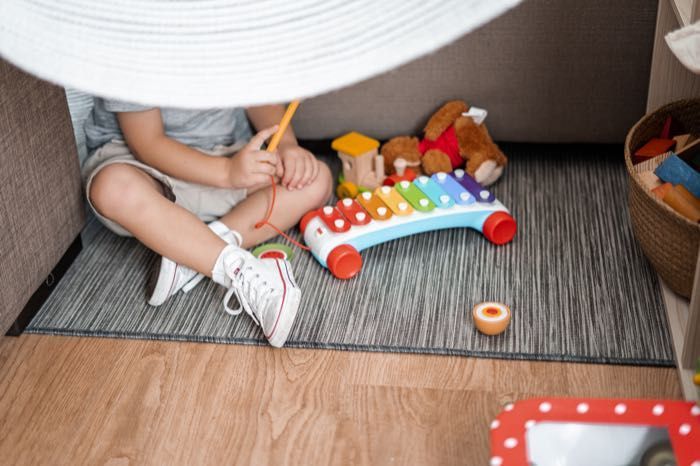 A little boy is sitting on the floor playing with toys.