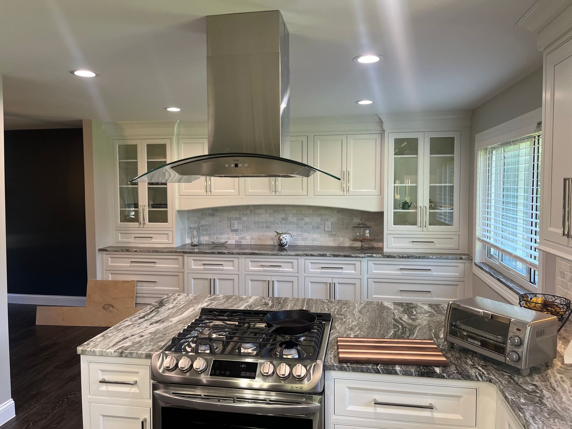 A kitchen with stainless steel appliances , granite counter tops , and white cabinets.