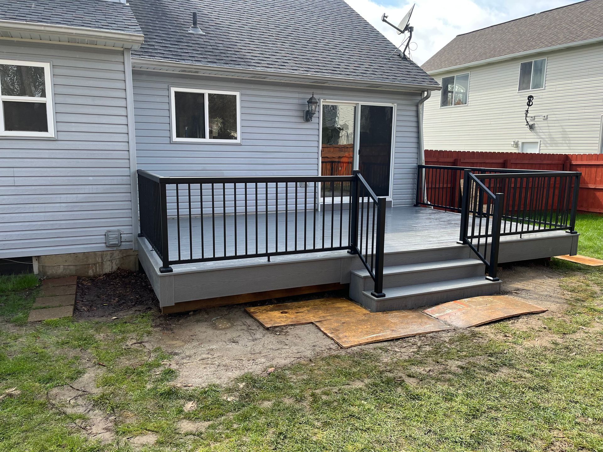 A house with a deck and stairs in the backyard.