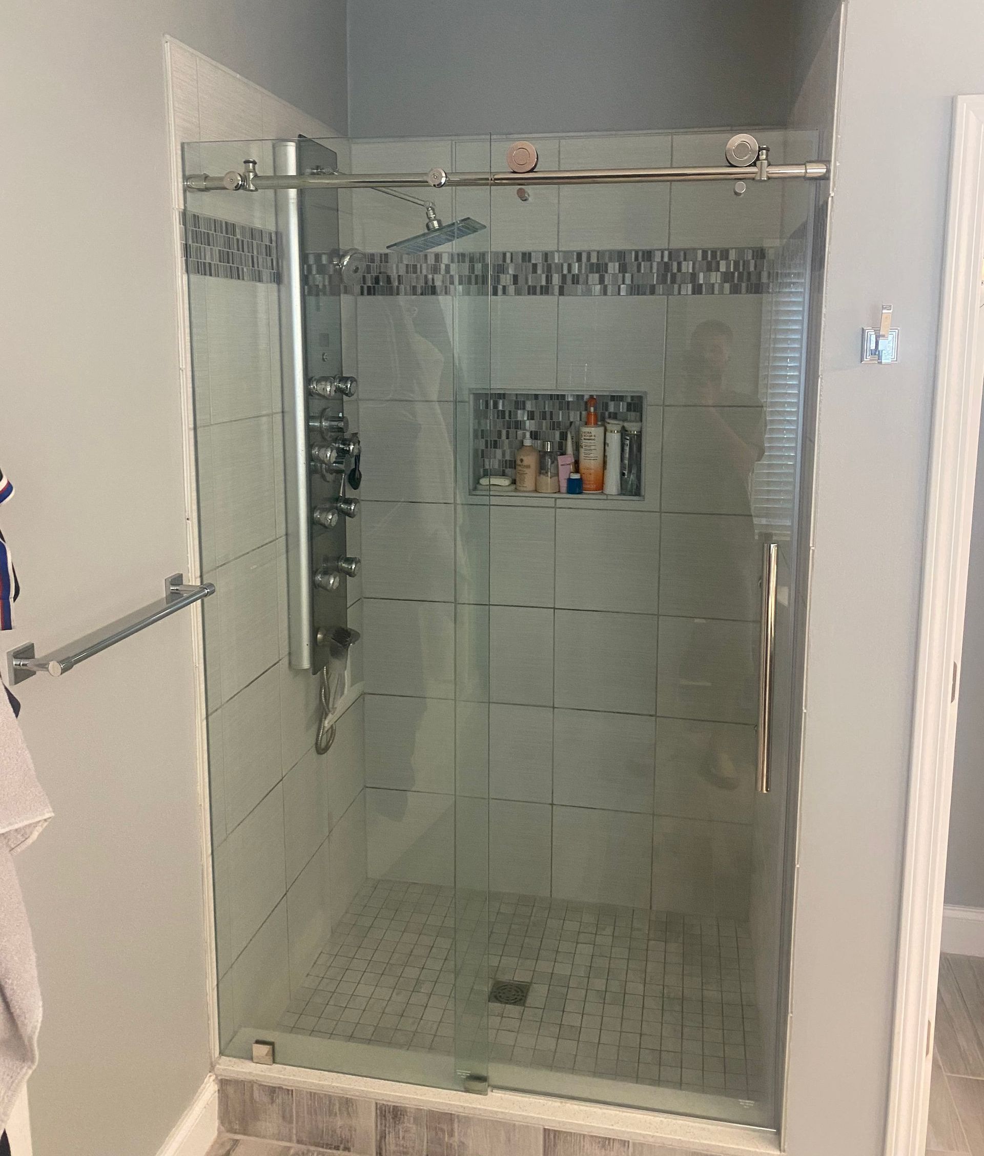 A bathroom with a sliding glass shower door.