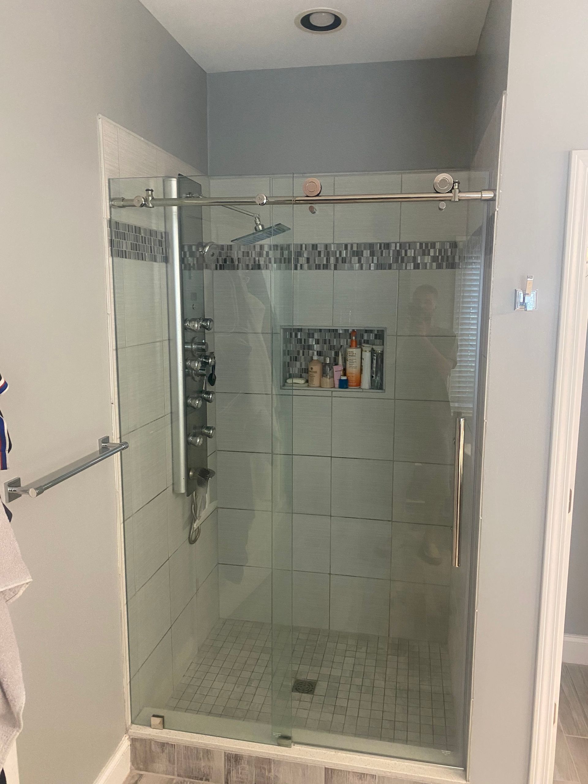 A bathroom with a sliding glass shower door.