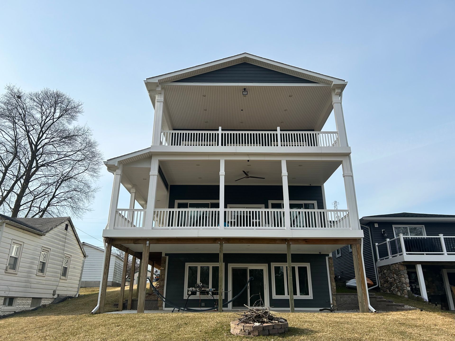 A large house with a lot of balconies and a fire pit in front of it.