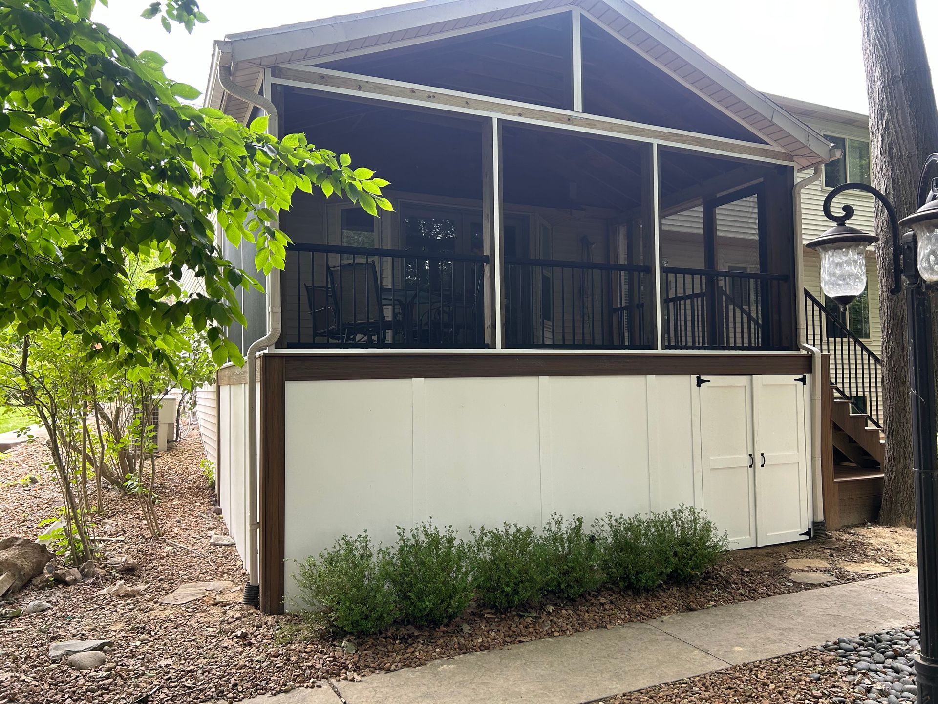 A mobile home with a screened in porch and stairs