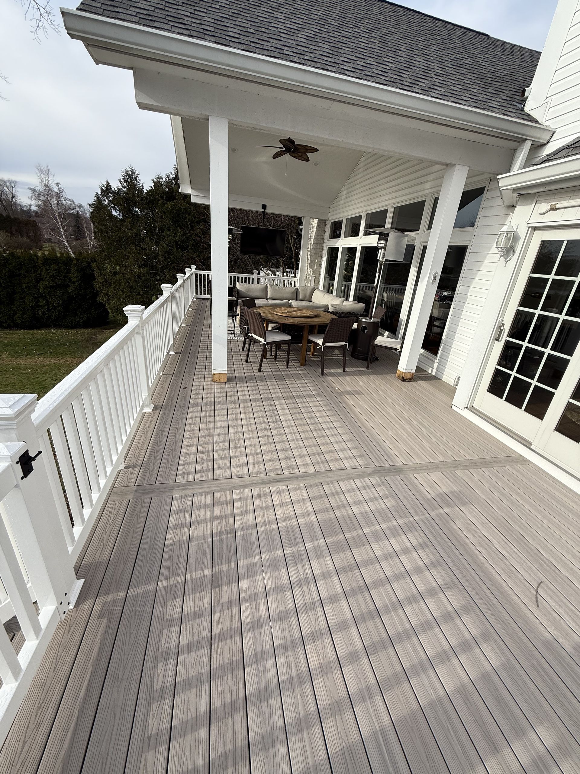 There is a large deck with a table and chairs on it.