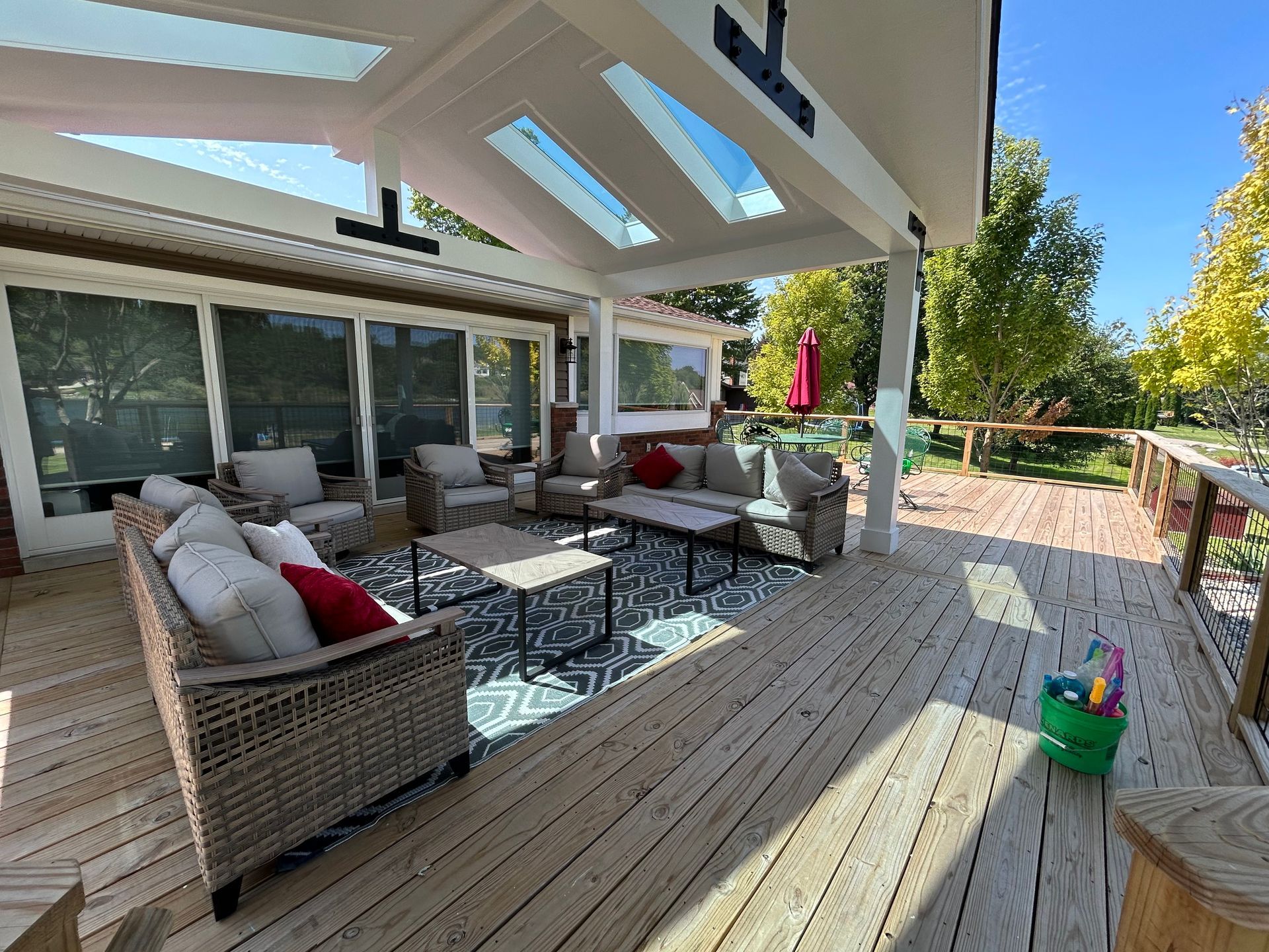 A large wooden deck with a lot of furniture on it.