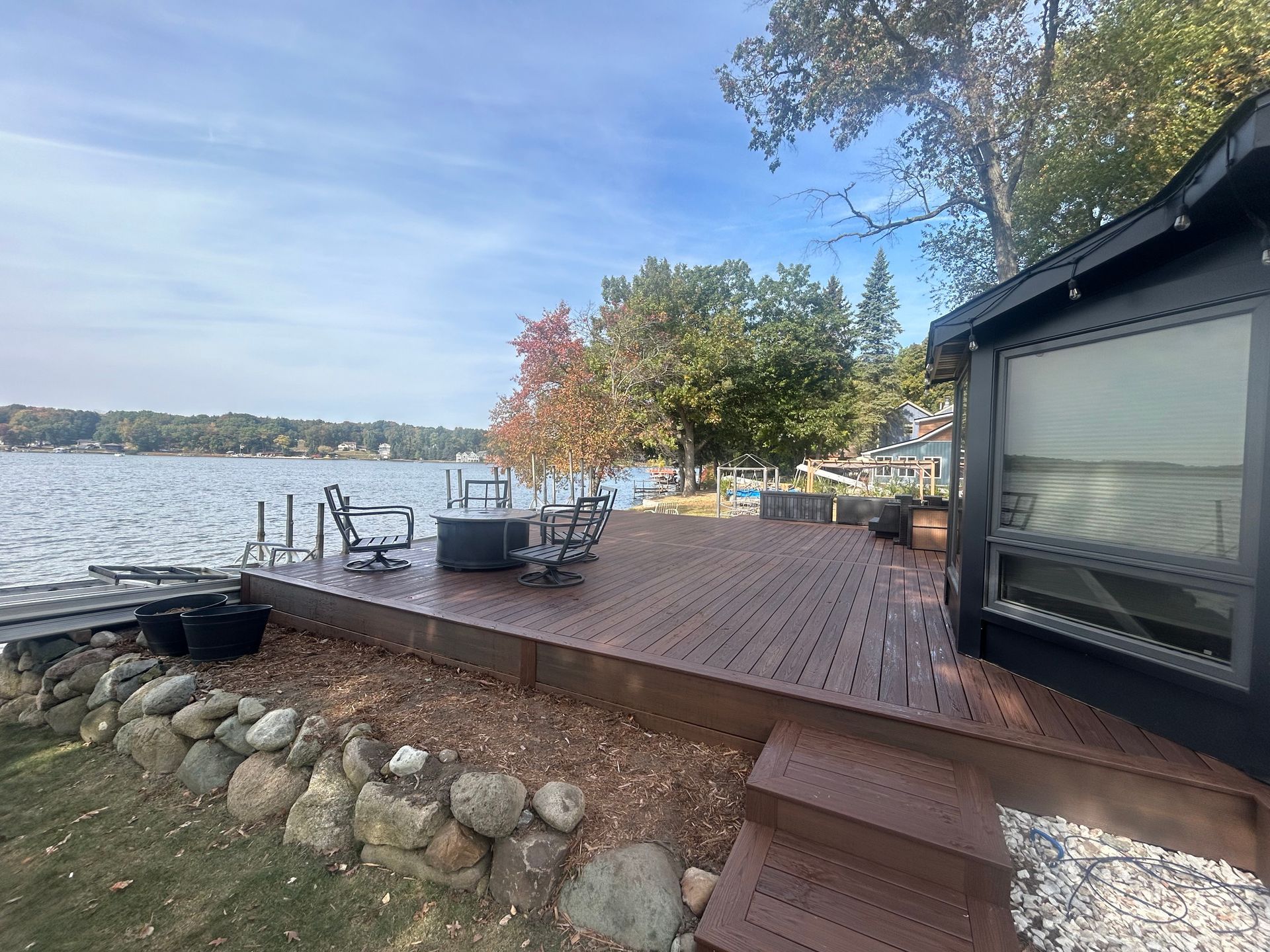 A house with a large deck overlooking a lake.