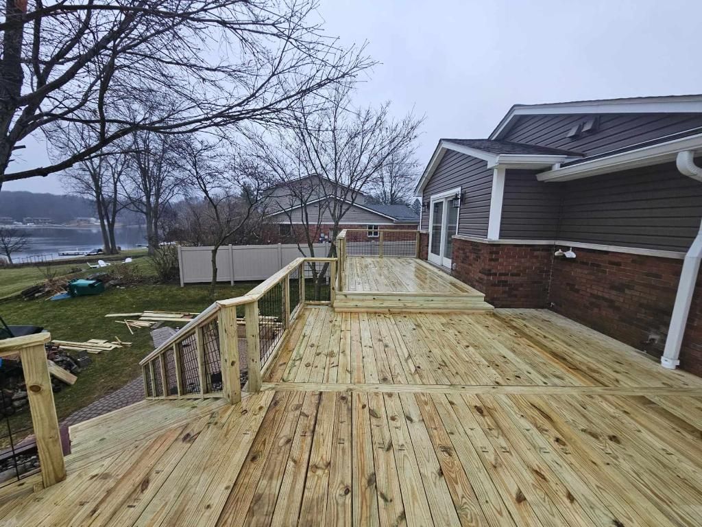 A wooden deck is being built in front of a house.
