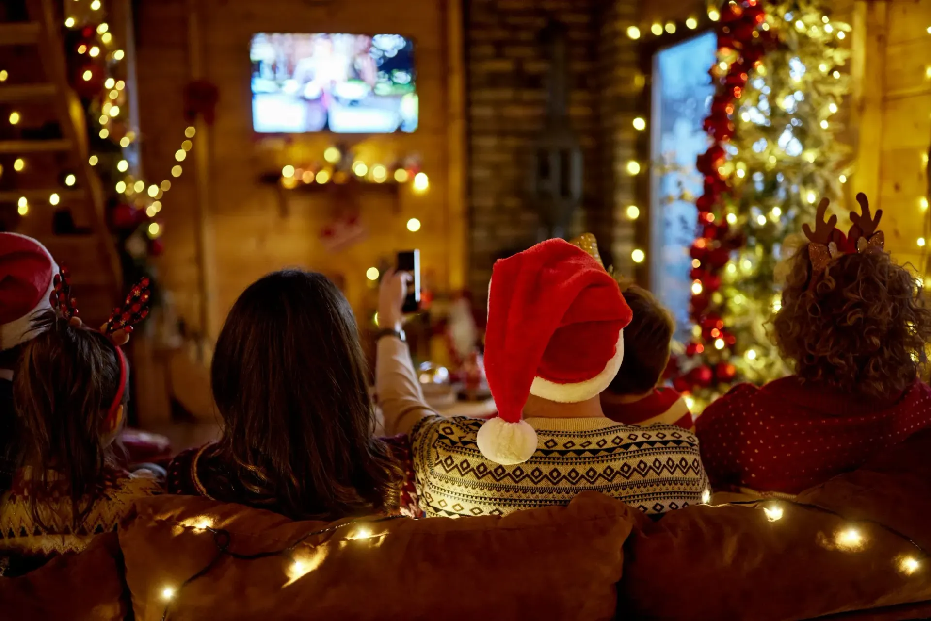 Family in a holiday-decorated Florida living room watching a TV with a buffering screen due to slow 