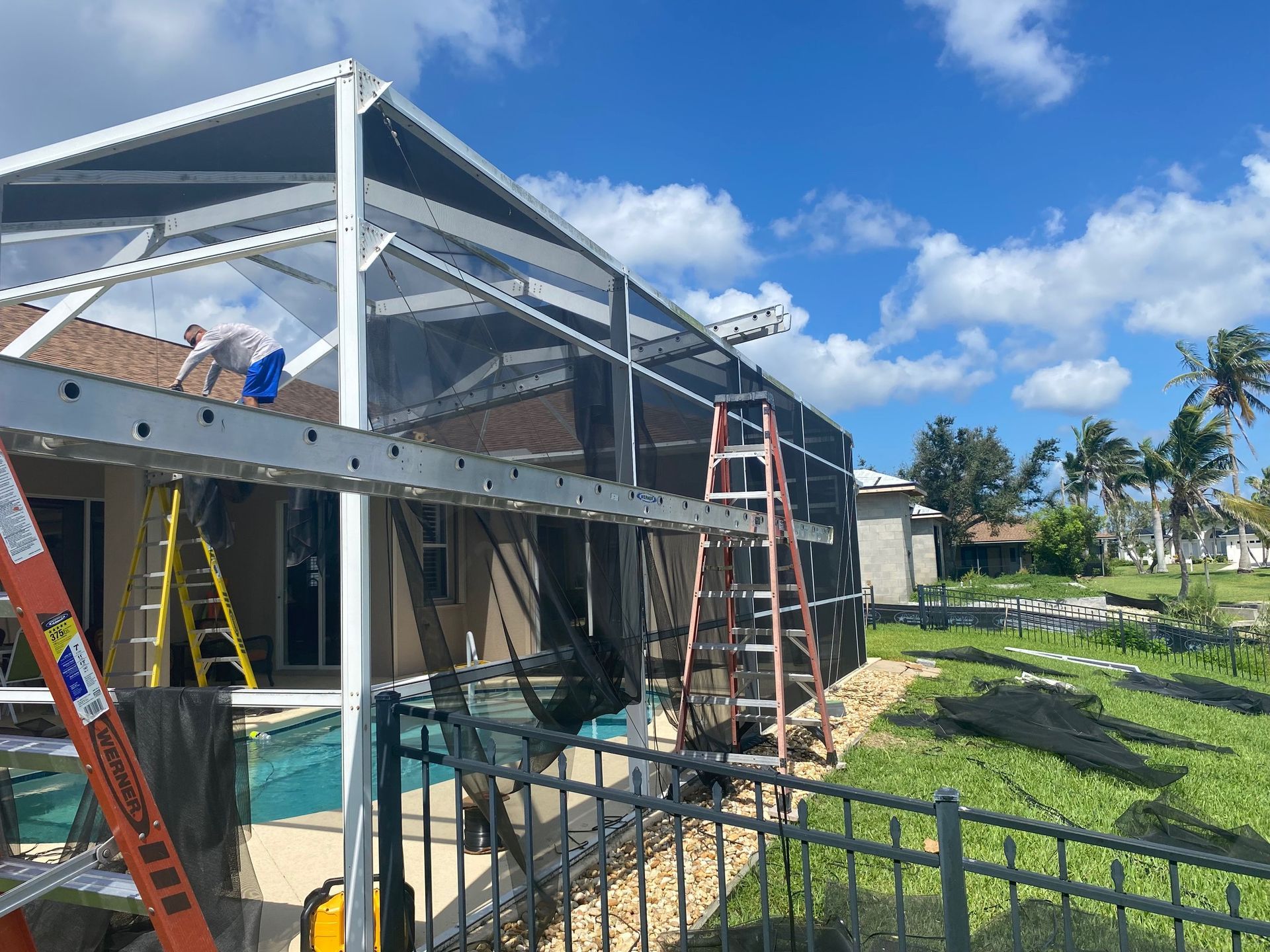 A pool enclosure is being built in front of a house.