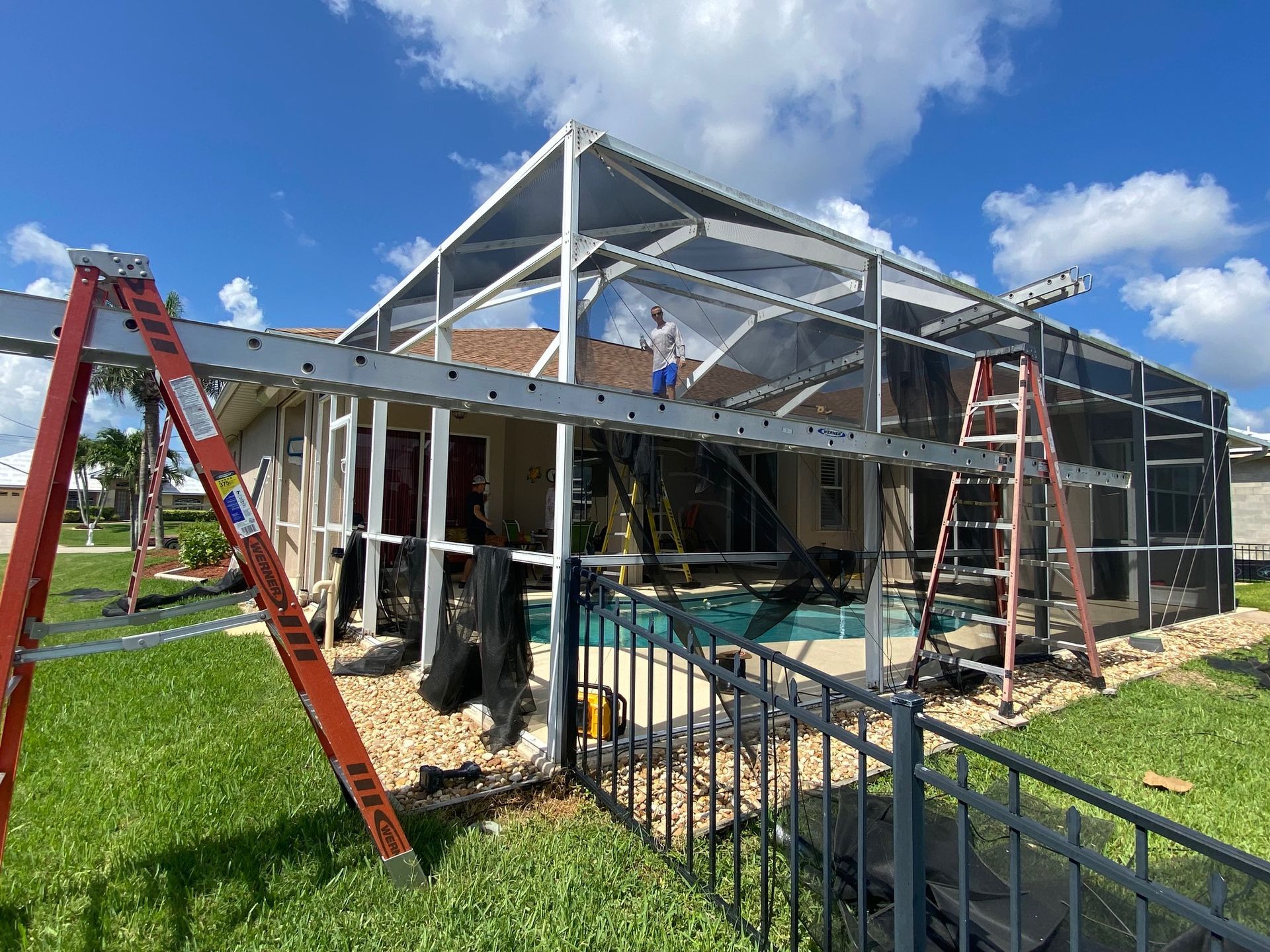 A house is being remodeled with a screened in pool area.