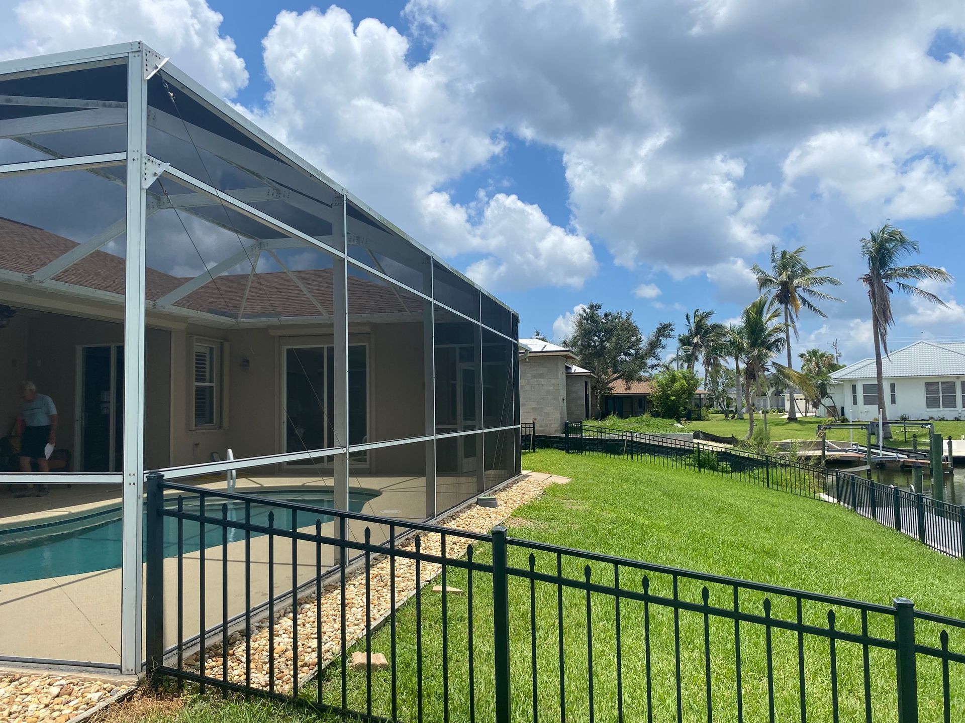 A house with a screened in pool and a fence around it