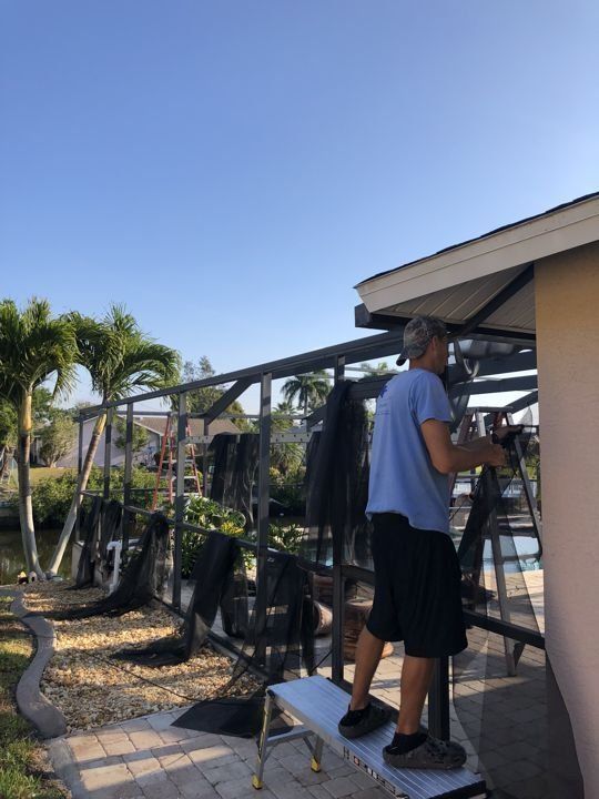 A man is standing on a ladder in front of a building
