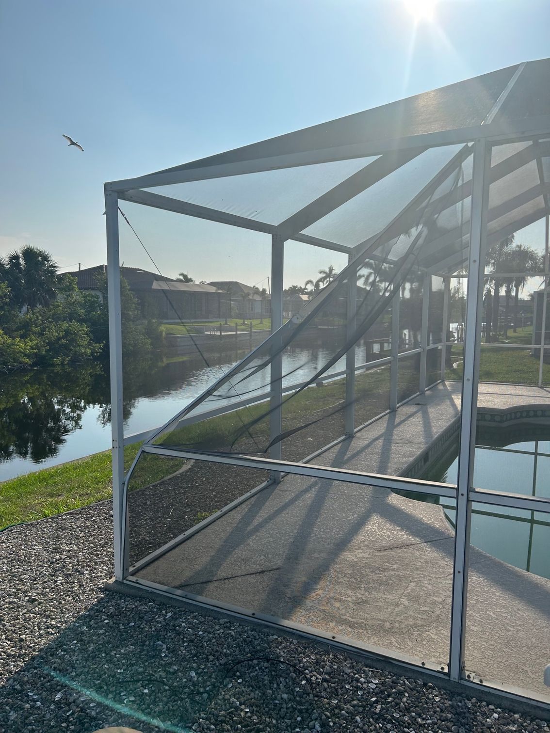 A screened in area next to a body of water.