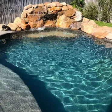 Pool With Rocky Waterfall, Clear Blue Water — Tru Blu Pools & Spas in Bluewater, QLD