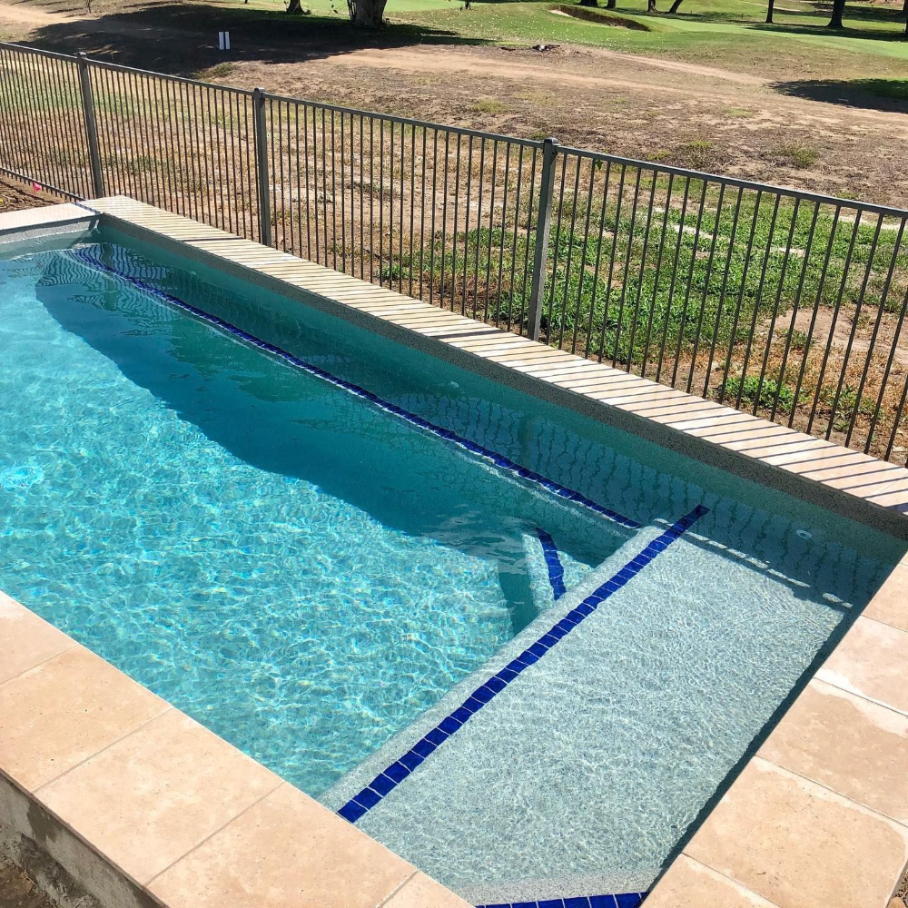 Pool with blue water and tiled edges, steps lead into the water— Tru Blu Pools & Spas in Bluewater, QLD